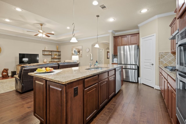 kitchen featuring stainless steel appliances, dark wood-style flooring, a sink, visible vents, and light stone countertops