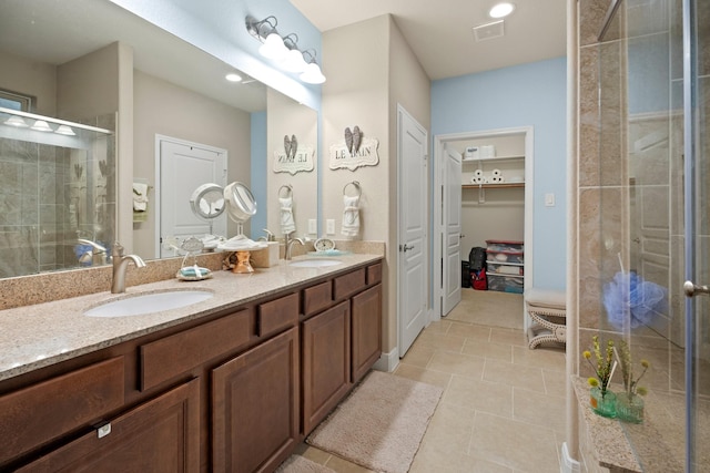 full bath with a stall shower, visible vents, a sink, and double vanity