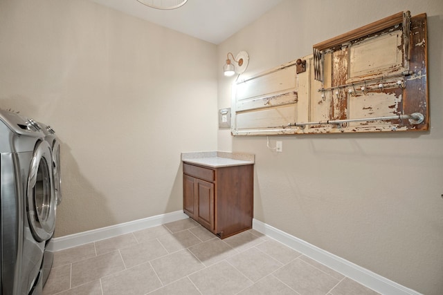 clothes washing area with laundry area, washer and clothes dryer, light tile patterned flooring, and baseboards