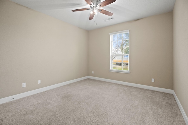 empty room featuring visible vents, baseboards, a ceiling fan, and light colored carpet