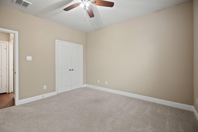 unfurnished bedroom featuring ceiling fan, carpet floors, visible vents, baseboards, and a closet