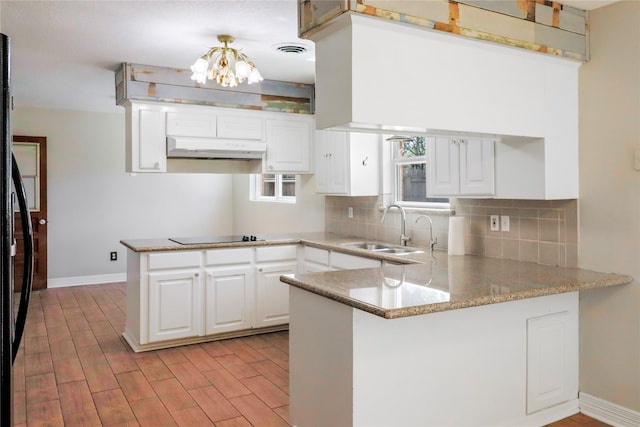 kitchen with visible vents, a sink, a peninsula, under cabinet range hood, and black appliances