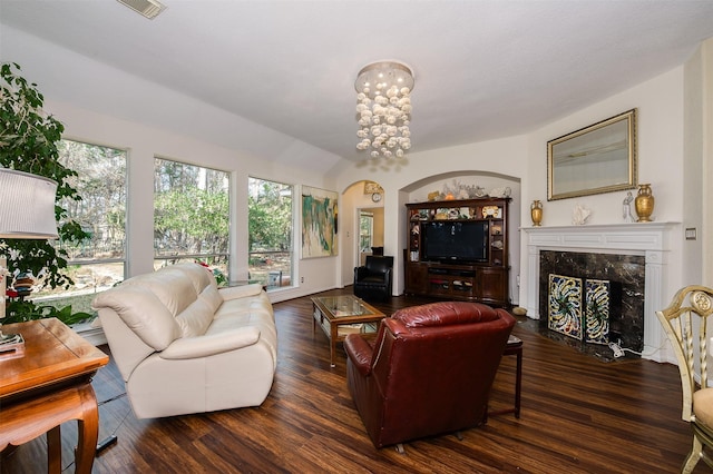 living room featuring visible vents, a chandelier, wood finished floors, and a high end fireplace