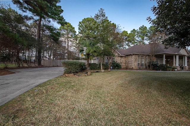 view of front of property featuring brick siding, a front yard, and fence