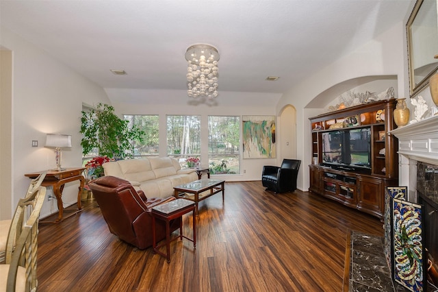 living area with a high end fireplace, visible vents, and wood finished floors