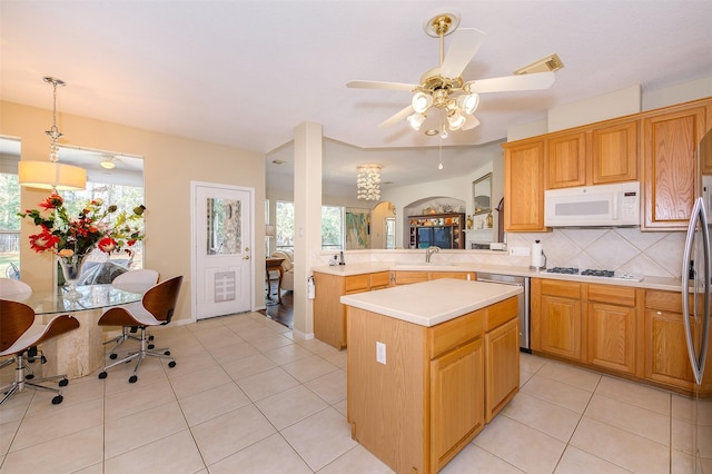 kitchen featuring light tile patterned flooring, white appliances, a sink, light countertops, and tasteful backsplash