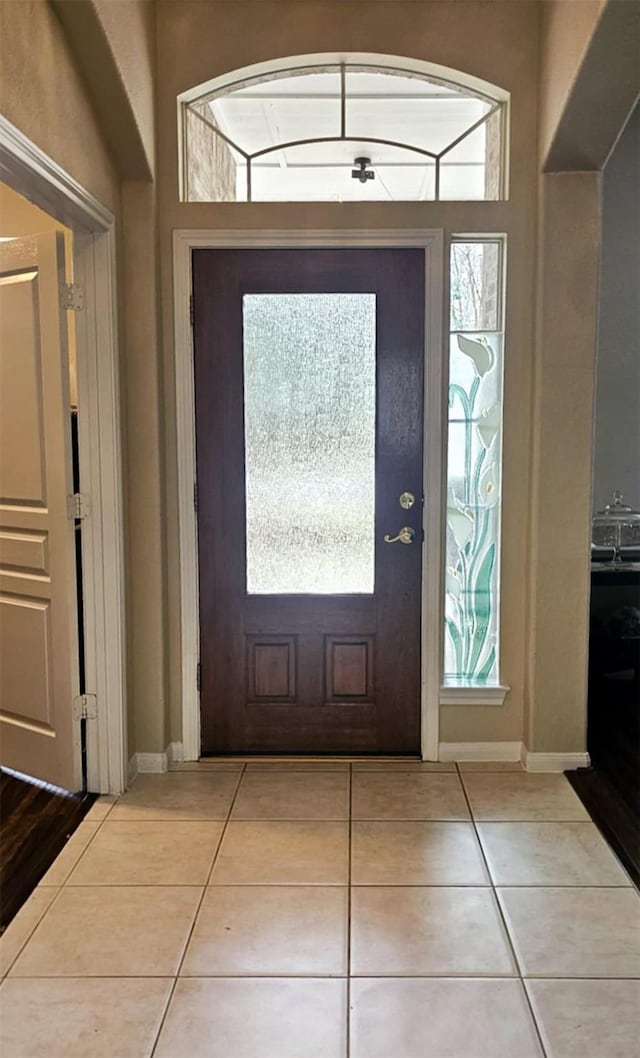 foyer featuring tile patterned flooring and baseboards