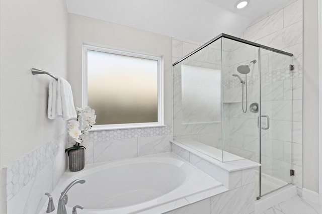 bathroom featuring a stall shower, marble finish floor, and a bath