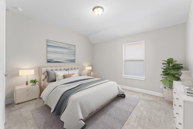 carpeted bedroom featuring vaulted ceiling and baseboards