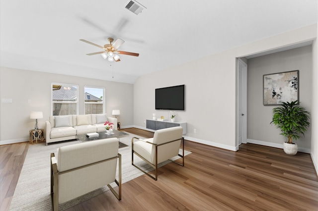 living room featuring ceiling fan, wood finished floors, visible vents, and baseboards