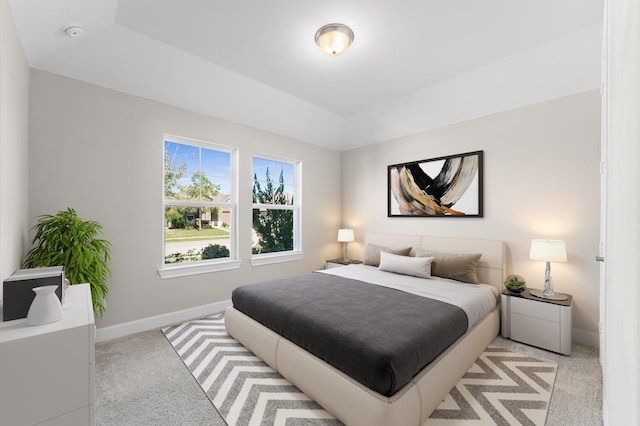 bedroom with light carpet and baseboards