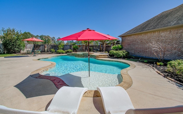 view of pool with a fenced backyard, a pool with connected hot tub, and a patio