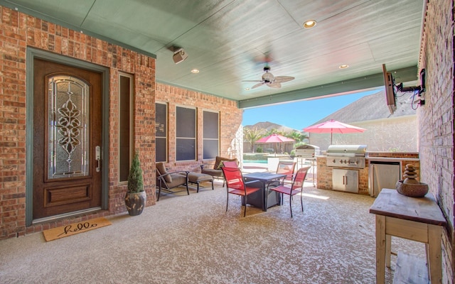 view of patio featuring exterior kitchen, grilling area, and a ceiling fan