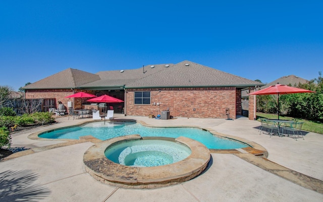 view of pool featuring a pool with connected hot tub and a patio area