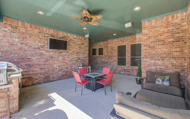 view of patio featuring a ceiling fan and an outdoor living space with a fire pit