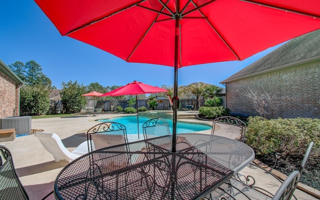 view of swimming pool with a fenced in pool, a fenced backyard, outdoor dining area, a patio area, and central AC