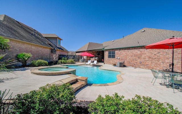 view of swimming pool featuring a pool with connected hot tub, a patio area, and fence