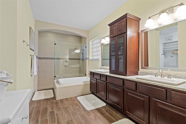 bathroom with tiled bath, wood tiled floor, a sink, and a tile shower