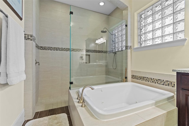 full bathroom with a whirlpool tub, a shower stall, and vanity