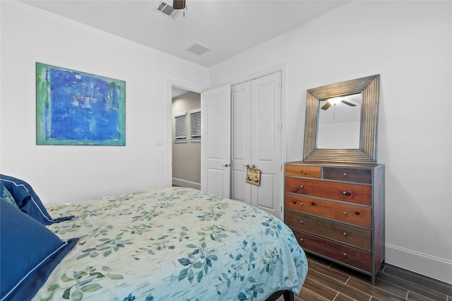 bedroom with baseboards, a closet, visible vents, and wood tiled floor