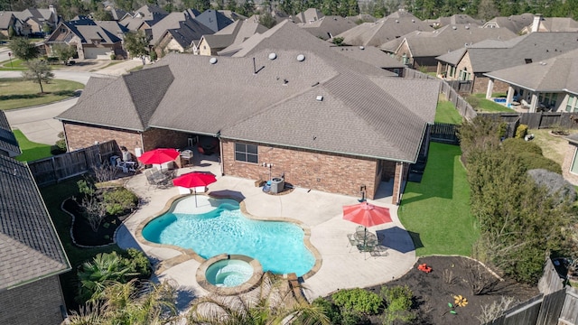 view of swimming pool with a patio area, a fenced backyard, a residential view, and a pool with connected hot tub