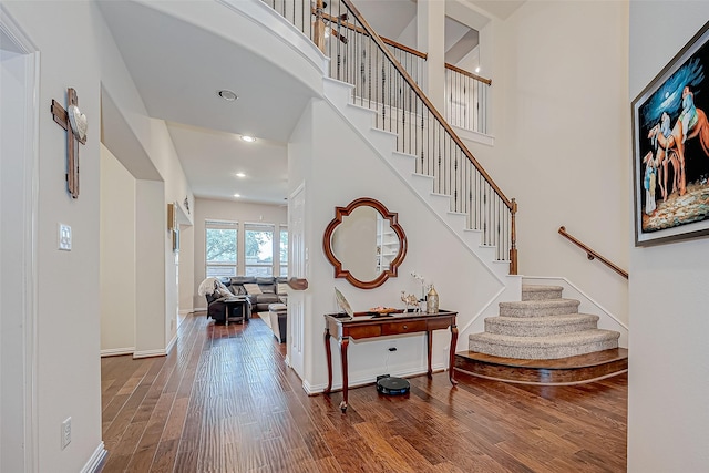 foyer featuring stairs, recessed lighting, baseboards, and wood finished floors