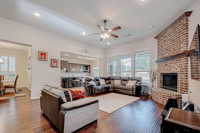 living room with a fireplace, recessed lighting, visible vents, wood finished floors, and baseboards