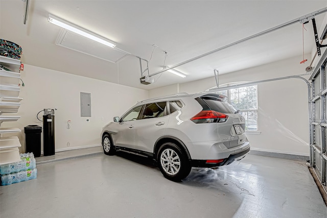 garage featuring baseboards, electric panel, and a garage door opener