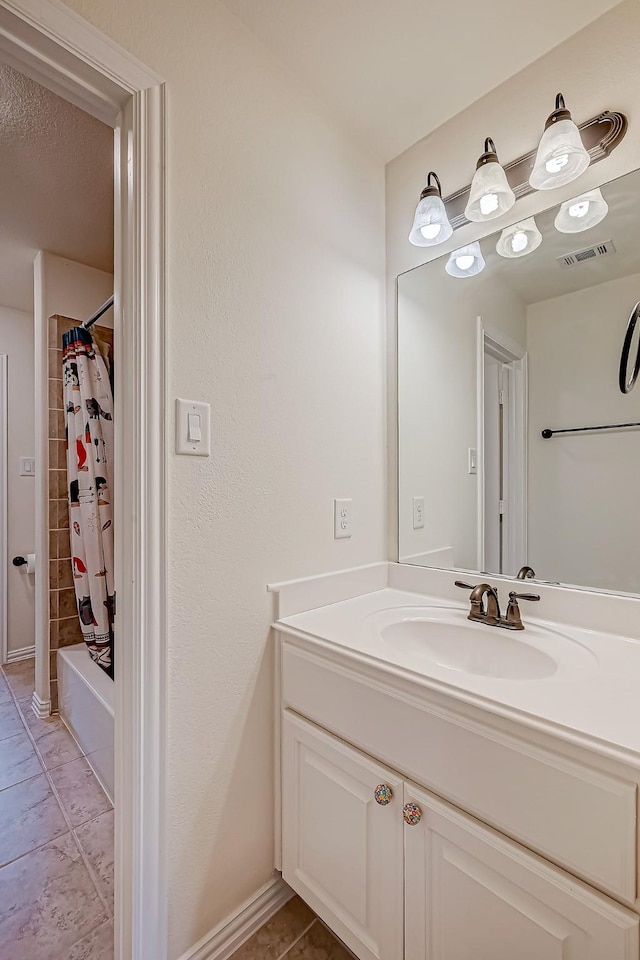 full bathroom featuring shower / bath combo with shower curtain, visible vents, vanity, and tile patterned floors