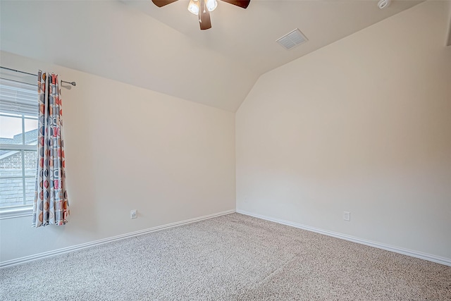 spare room with baseboards, visible vents, a ceiling fan, lofted ceiling, and carpet floors