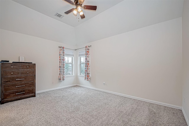 spare room featuring ceiling fan, lofted ceiling, light carpet, visible vents, and baseboards