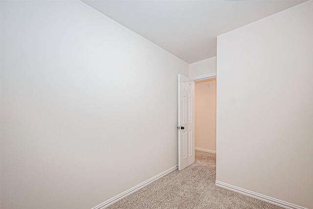 unfurnished room with light carpet and baseboards