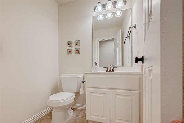 half bath featuring tile patterned flooring, baseboards, vanity, and toilet