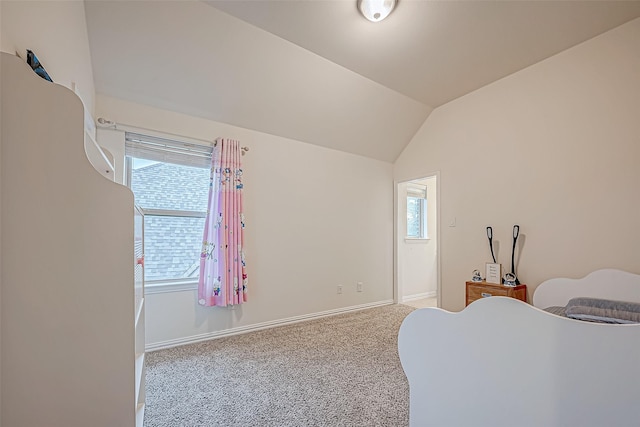 carpeted bedroom with lofted ceiling and baseboards