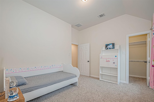 carpeted bedroom featuring lofted ceiling, baseboards, a spacious closet, and visible vents