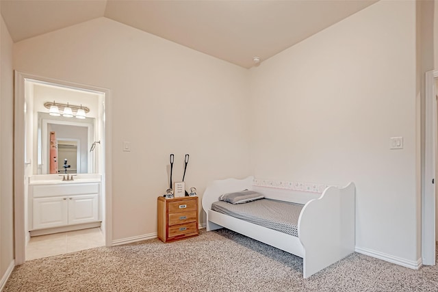 bedroom with lofted ceiling, light colored carpet, baseboards, and ensuite bathroom