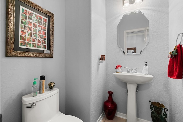 half bath featuring toilet and a sink