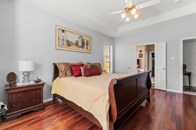 bedroom with baseboards, a raised ceiling, ceiling fan, and dark wood-style flooring