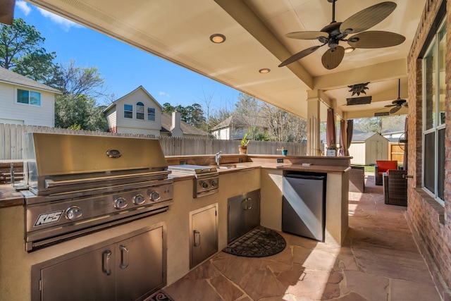 view of patio featuring grilling area, ceiling fan, a shed, an outdoor structure, and a fenced backyard