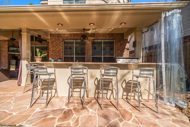 view of patio / terrace featuring outdoor wet bar, area for grilling, and a ceiling fan