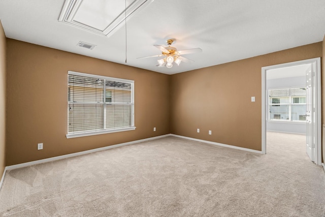 spare room featuring attic access, carpet flooring, baseboards, and visible vents