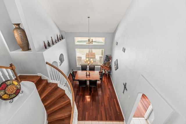 interior space featuring stairs, wood finished floors, baseboards, and a chandelier