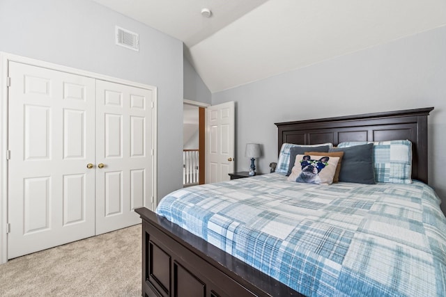 bedroom featuring a closet, visible vents, light colored carpet, and vaulted ceiling