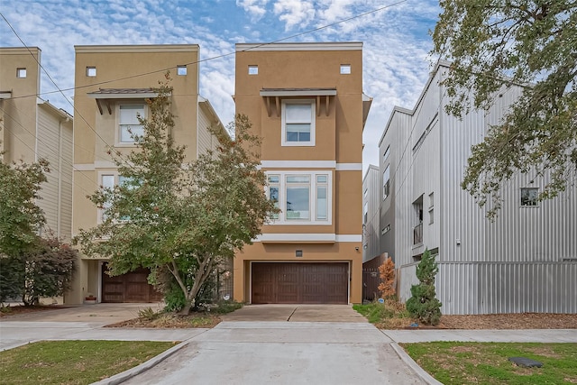 view of front of property featuring driveway, an attached garage, and stucco siding