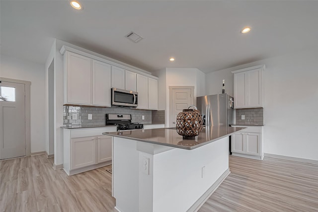 kitchen featuring stainless steel appliances, light wood-type flooring, a kitchen island, and visible vents