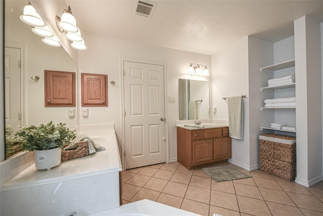 bathroom with baseboards, visible vents, tile patterned floors, vanity, and a notable chandelier