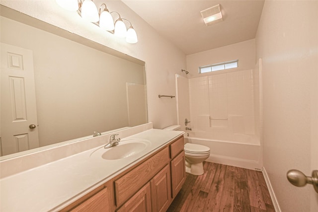 bathroom featuring toilet, wood finished floors, vanity, baseboards, and shower / washtub combination