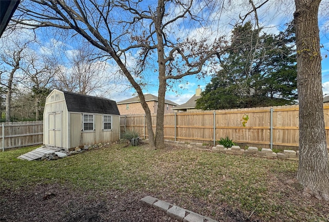 view of yard featuring a fenced backyard, a storage unit, and an outbuilding