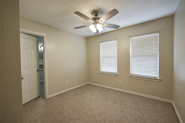 unfurnished room featuring carpet floors, ceiling fan, and baseboards