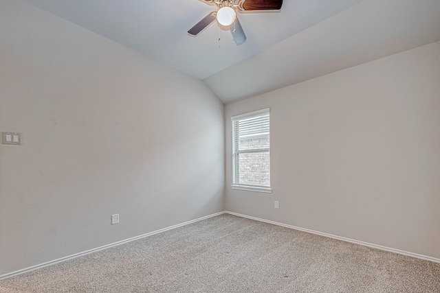 carpeted spare room featuring vaulted ceiling, a ceiling fan, and baseboards